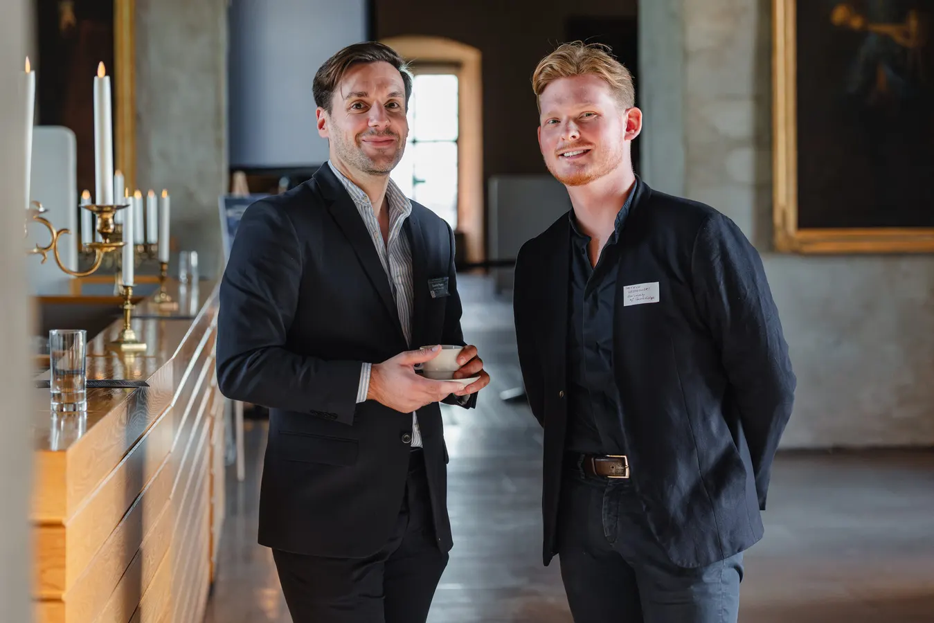 Two conference guests smiling during a coffee break