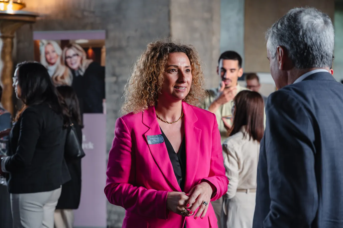 Conference guest in a pink blazer during networking