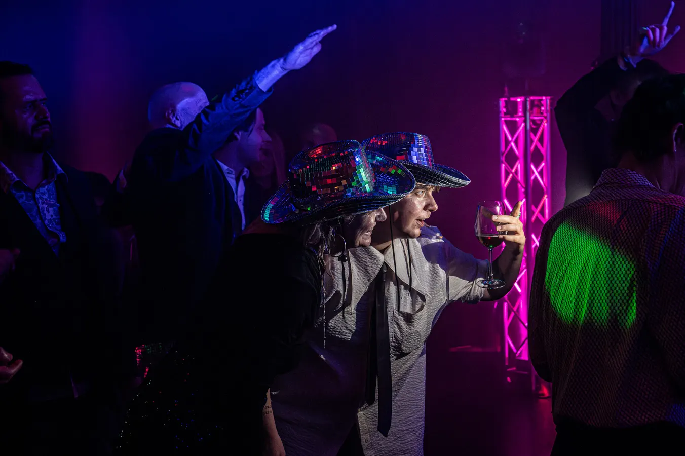 Guests in sequinned hats at an evening party
