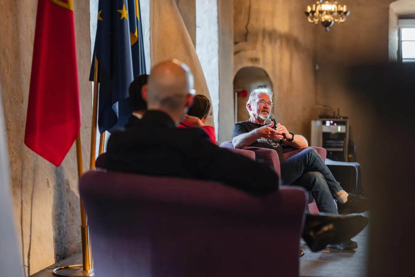 Panel discussion with speakers seated in armchairs
