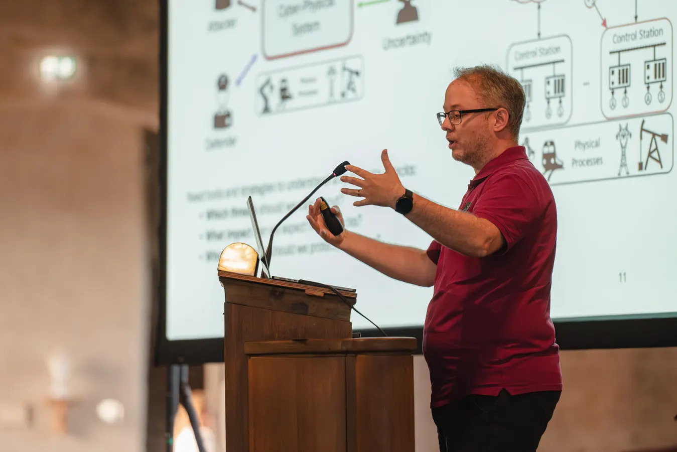 Speaker at a wooden lectern explaining a slide