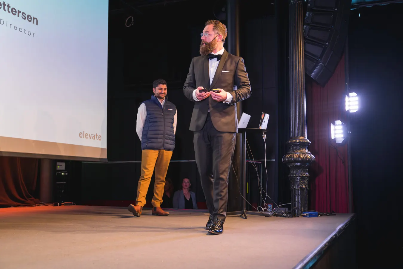 Two presenters on stage at a conference