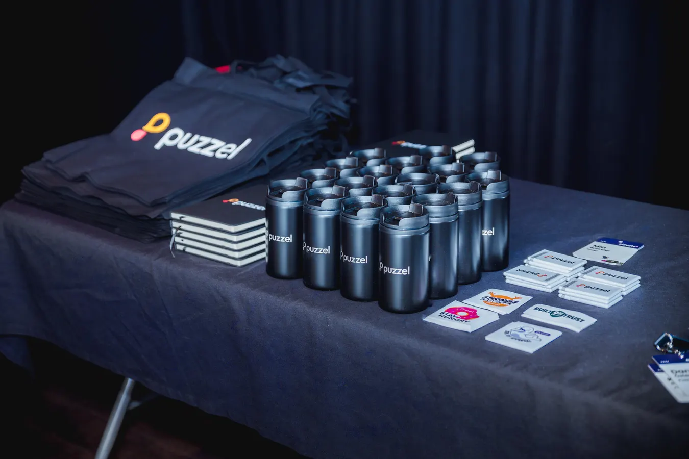 Branded cups and tote bags on a conference table