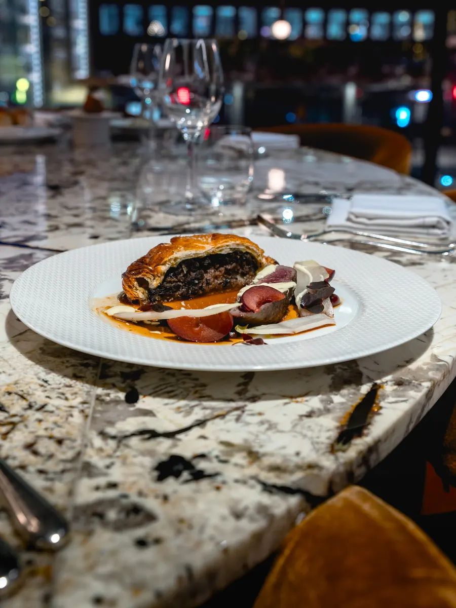 Beef Wellington plated on a marble restaurant table