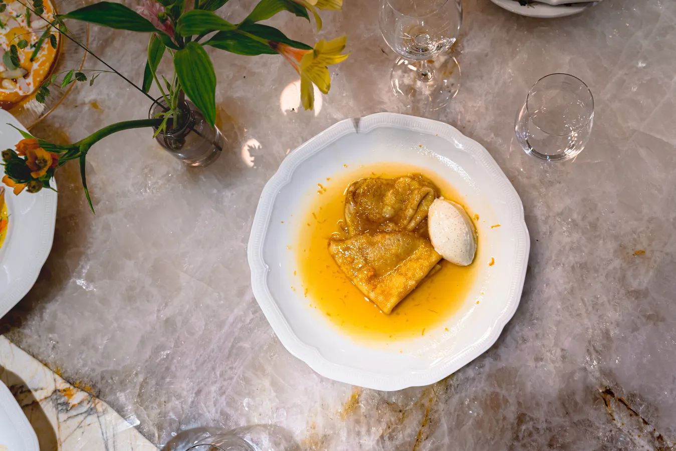 Crêpes in orange sauce with a scoop of ice cream