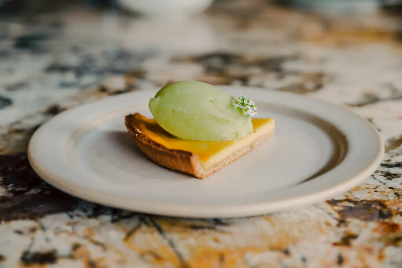 Lemon tart with a scoop of green sorbet