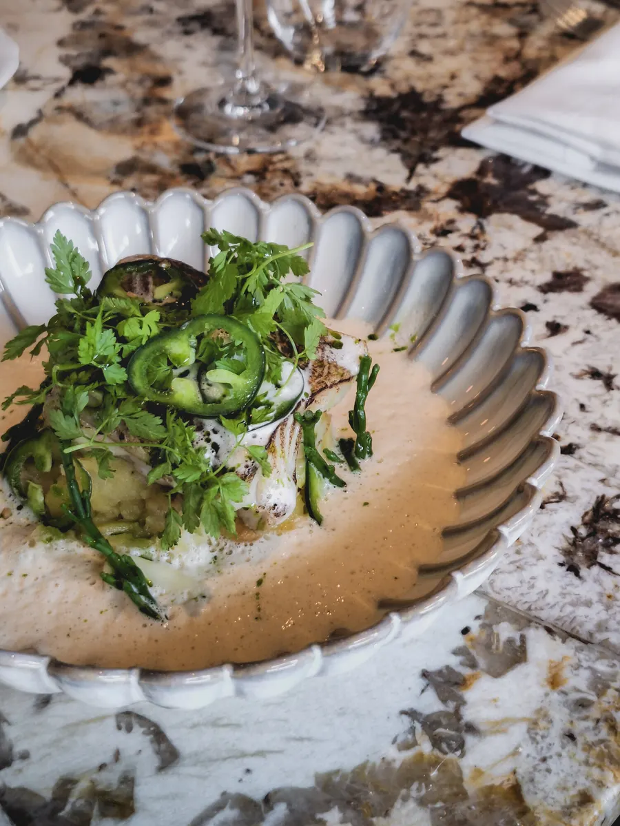 Fish with herbs and jalapeño in a scalloped bowl