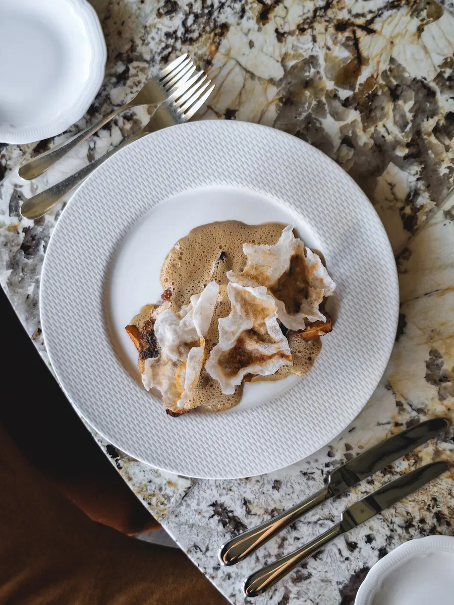Crisps with foam on a white plate, seen from above