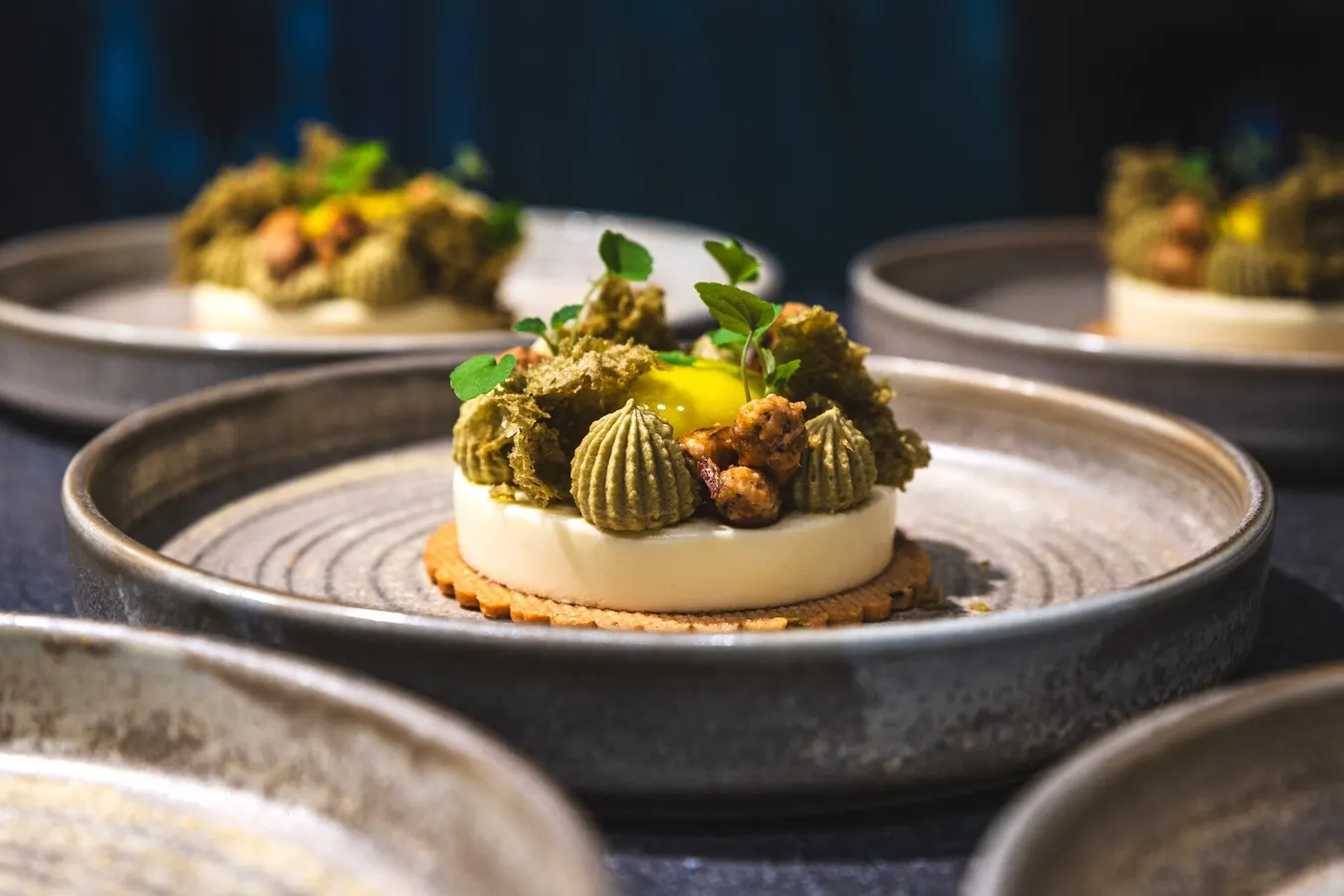 Pistachio dessert plated with micro herbs