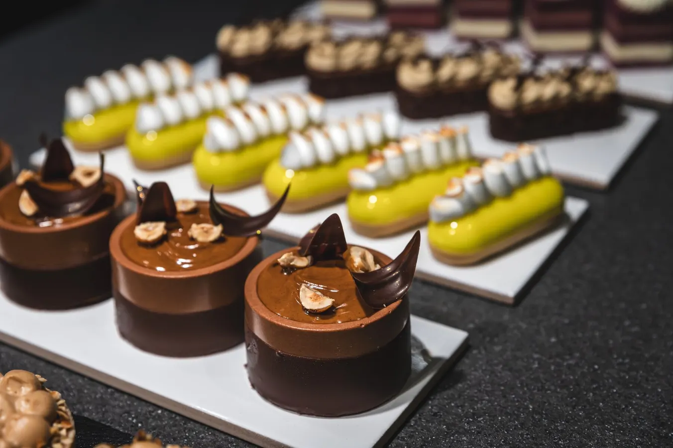 Lemon éclairs and chocolate mousse cakes on a counter